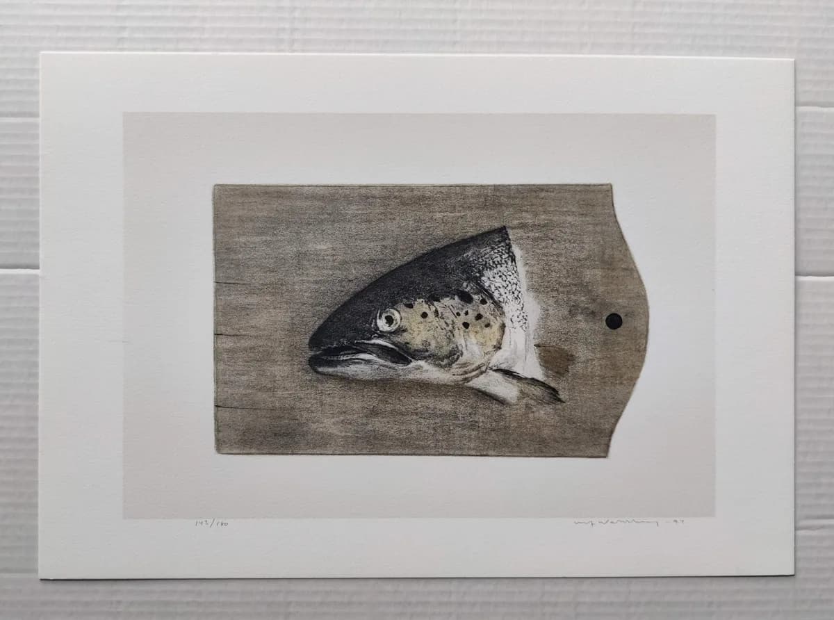 A sea trout's head shown lying on a wooden cutting board, in muted grey and brown tones.